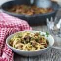 zoodles mit champigninsauce in einer hellgrauen schale mit pfanne im hintergrund