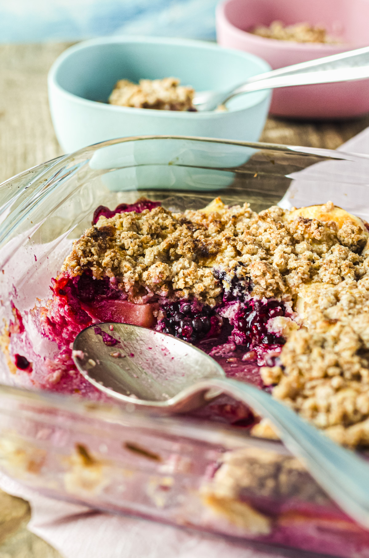 Apfel-Brombeer-Auflauf mit Streuseln in Glasform mit Löffel