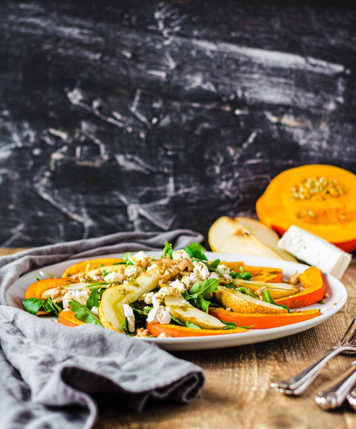 Herbstlicher Salat mit Kürbis auf weißem Teller