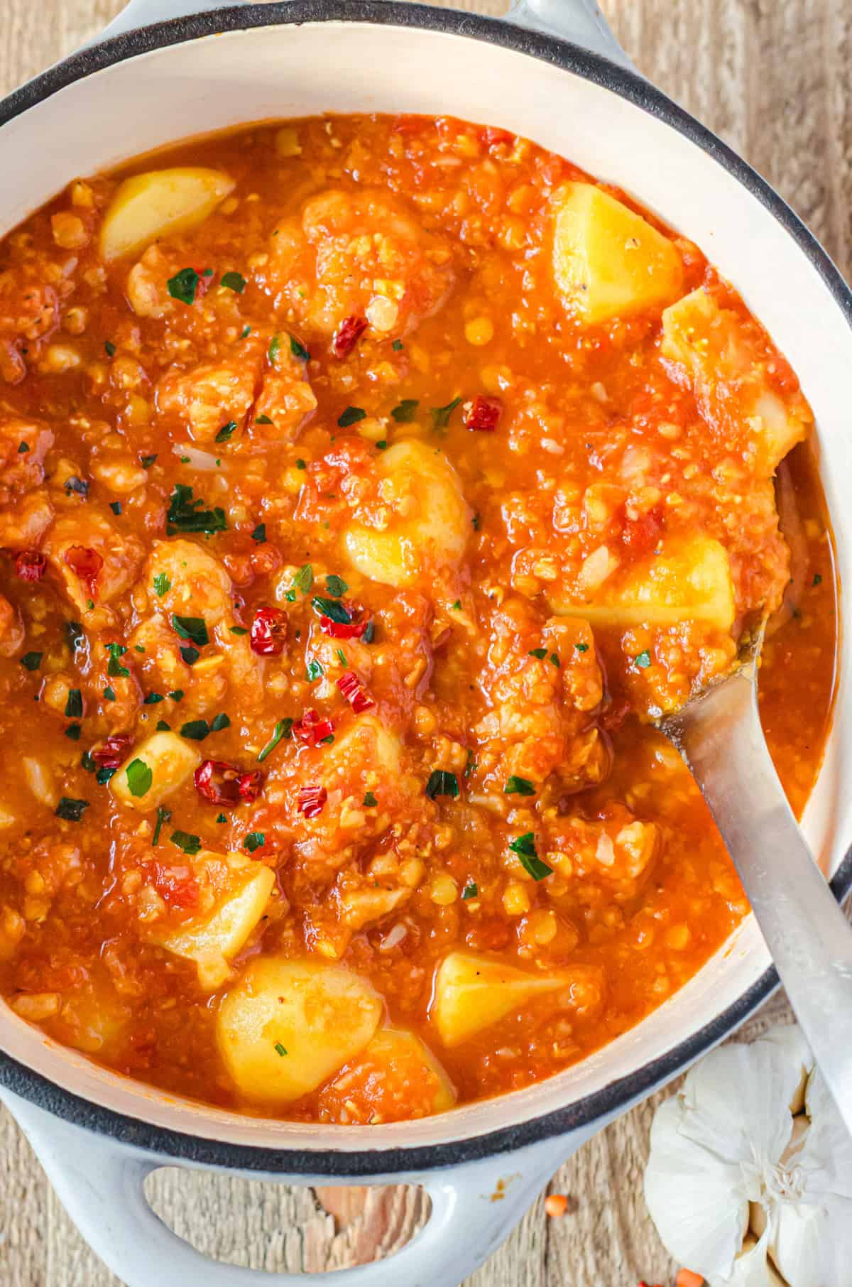 Mildes Curry mit Blumenkohl und Kartoffeln in hellgrauem Topf von oben, Nahaufnahme