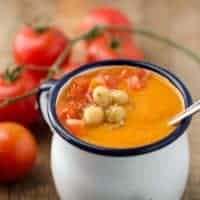 Kichererbsen-Tomatensuppe in weißer Emailtasse mit blauem Rand