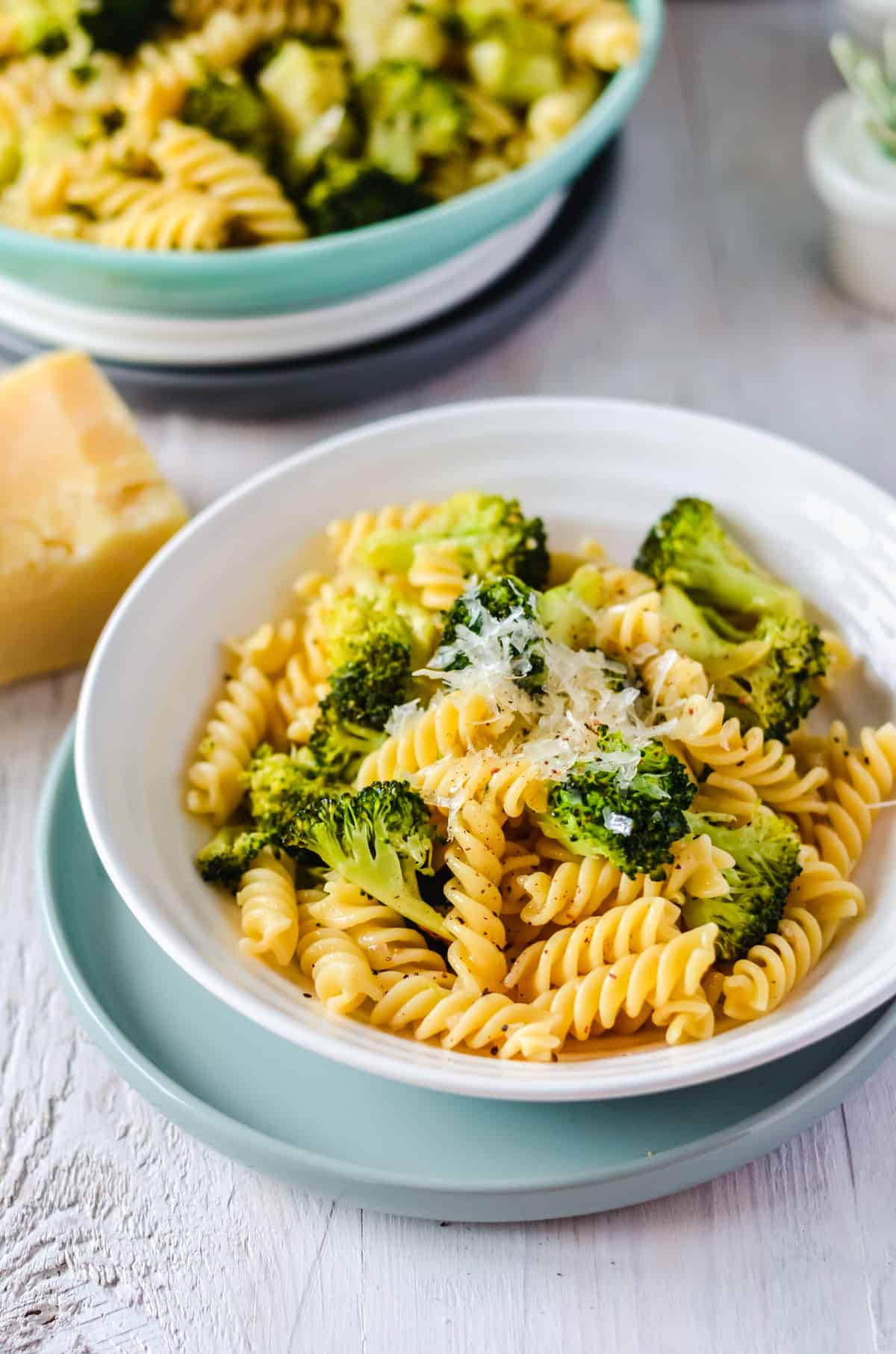 Nudeln mit Brokkoli und Parmesan in weißer Schale, Parmesan daneben