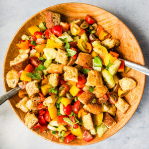 Panzanella in einer Holzschüssel mit Servierbesteck, von oben