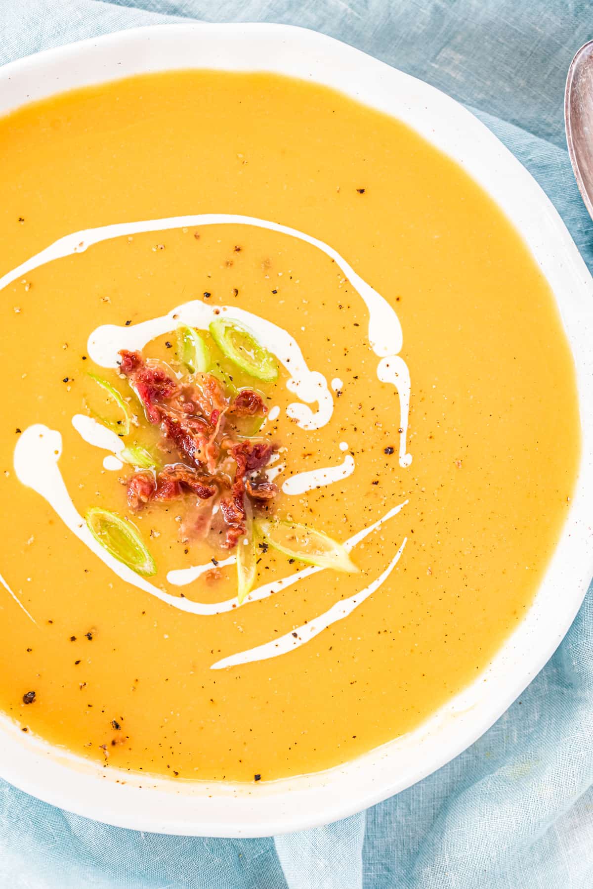 Süßkartoffel-Blumenkohlsuppe in einer weißen Schüssel. Nahaufnahme von oben.