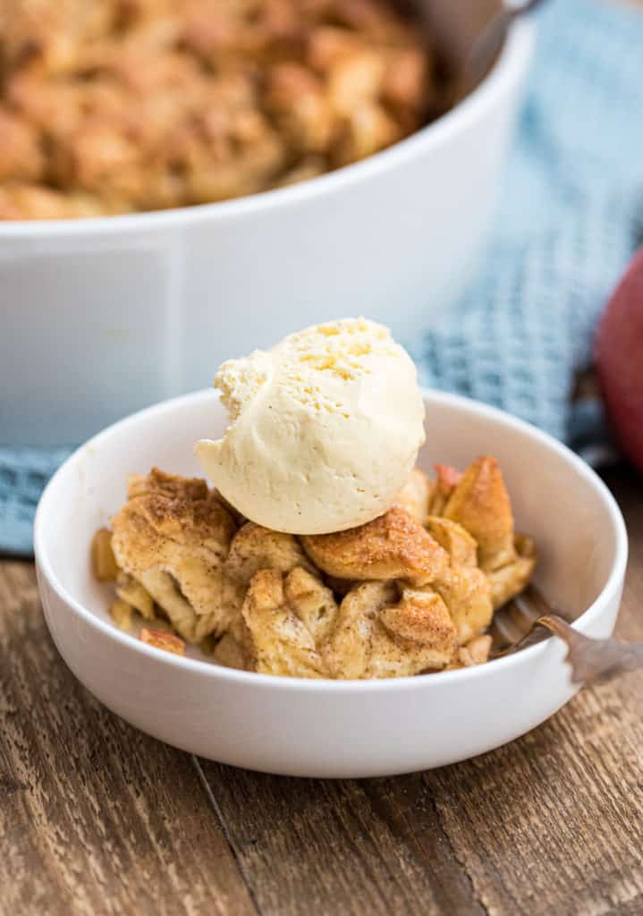 Nahaufname einer Portion Brotauflauf mit einer Kugel Vanilleeis in weißer Dessertschale
