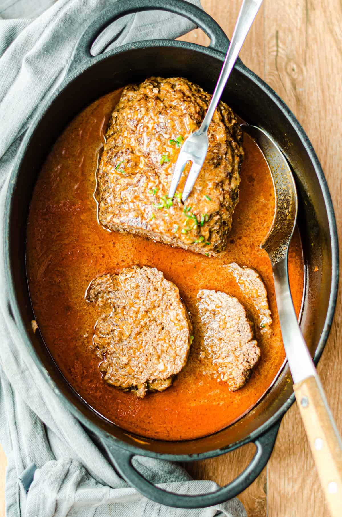 angeschnittener Hackbraten mit Gabel in einem Bratentopf, von oben