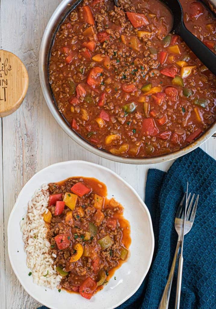 Paprika-Hackpfanne mit Reis auf Teller und in Pfanne von oben fotografiert.