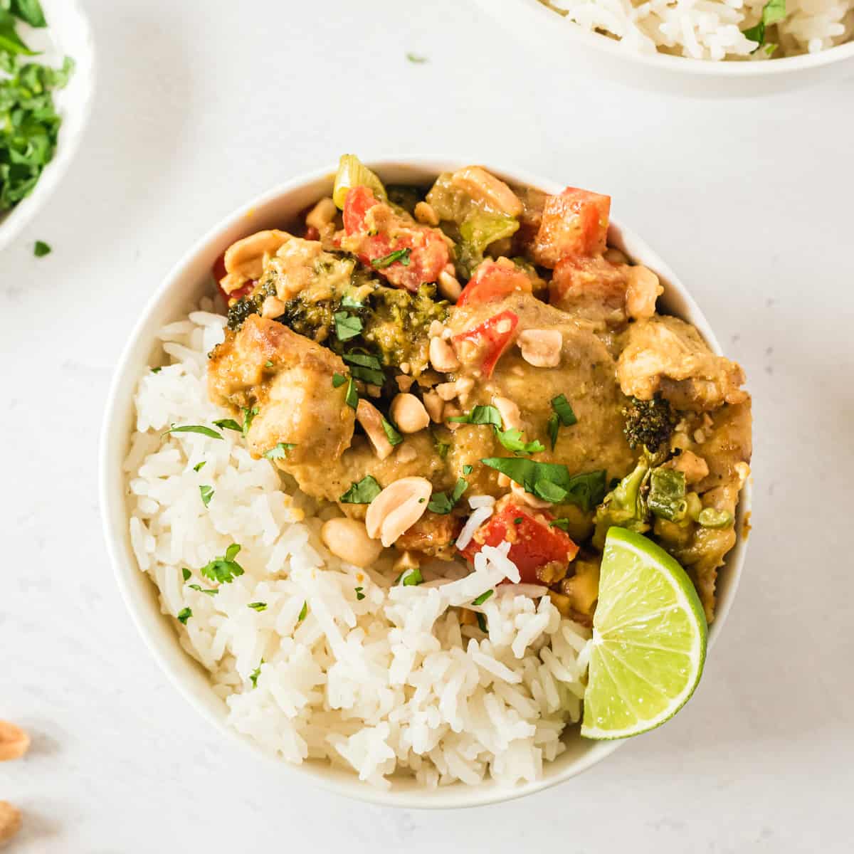 Hähnchen Curry mit Erdnusssauce und Reis in heller Schale von oben