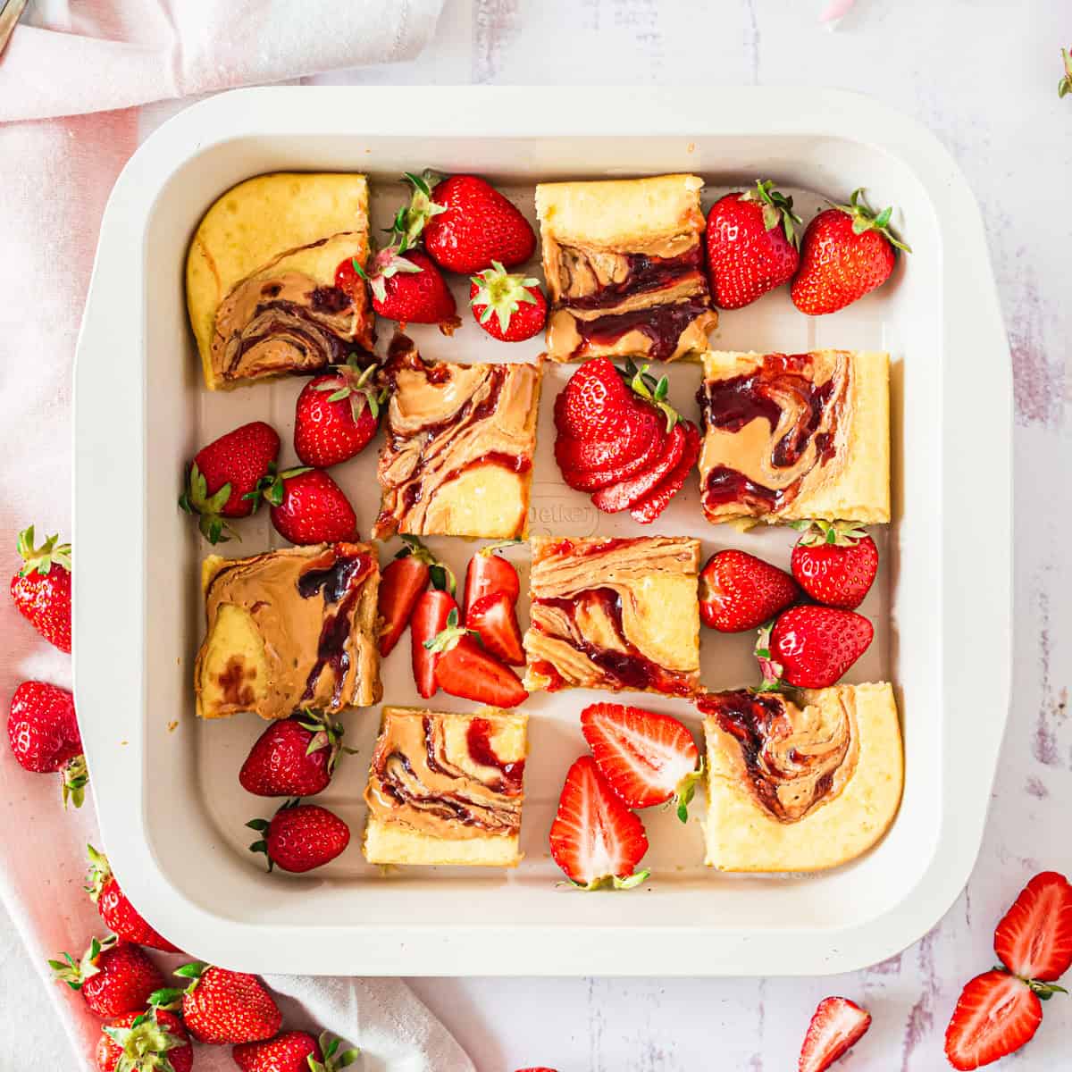 Ofenpfannkuchen mit Erdbeeeren und Erdnussbutter in weißer Brownieform von oben