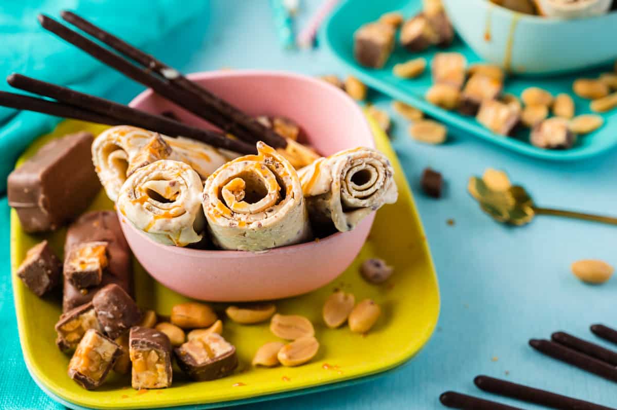 Ice-Rolls mit Karamellsauce und Erdnüssen in rosa schale