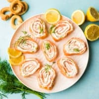 Lachsröllchen auf einem weißen Teller flatlay