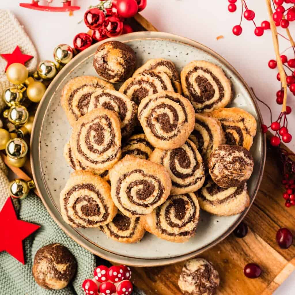 Schwarz-Weiß-Gebäck auf einem hellen Teller mit Weihnachtsdeko drumherum