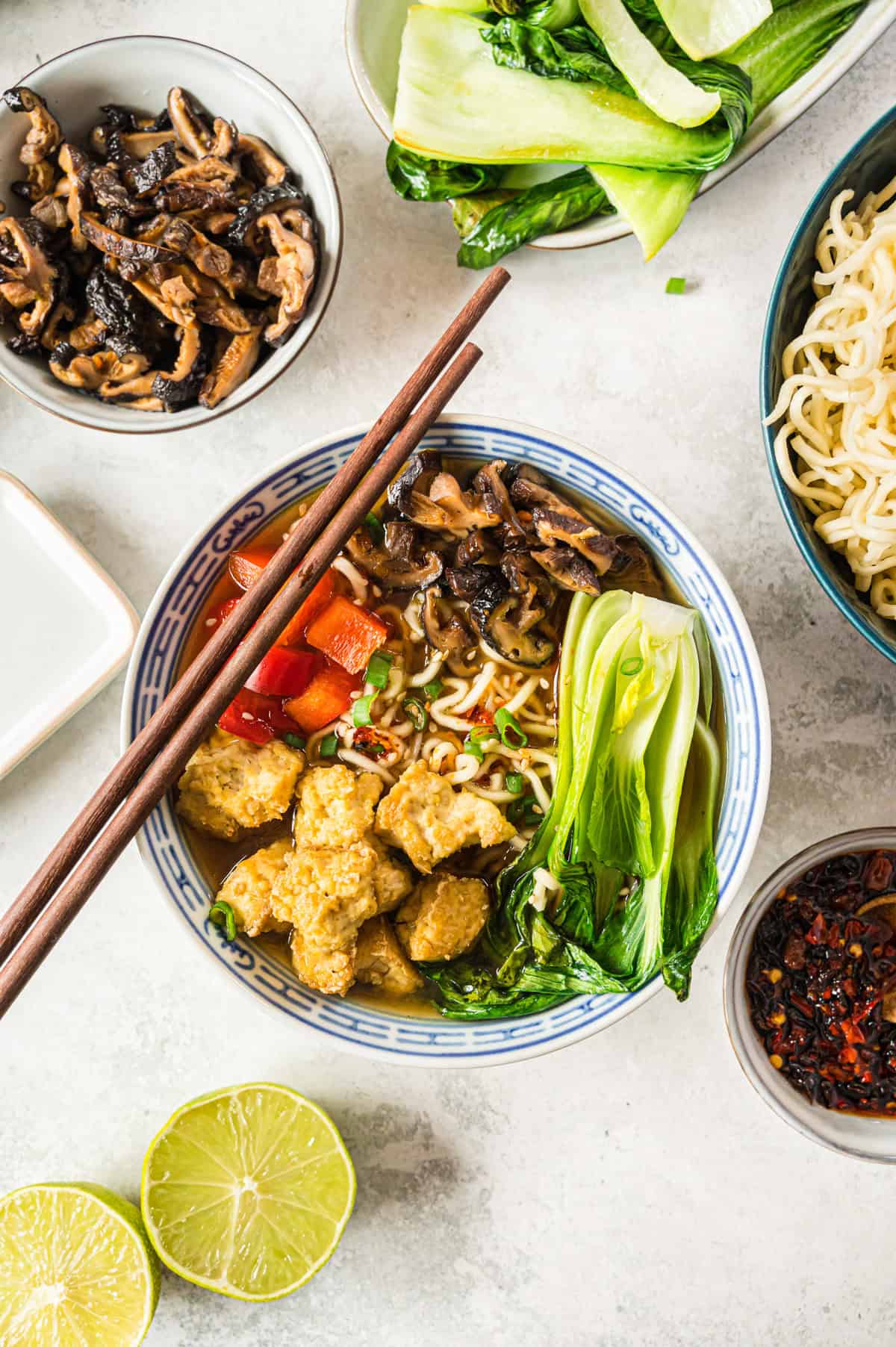 Ramen mit Tofu und Gemüse in blau-weißer Schale mit Holzstäbchen von oben