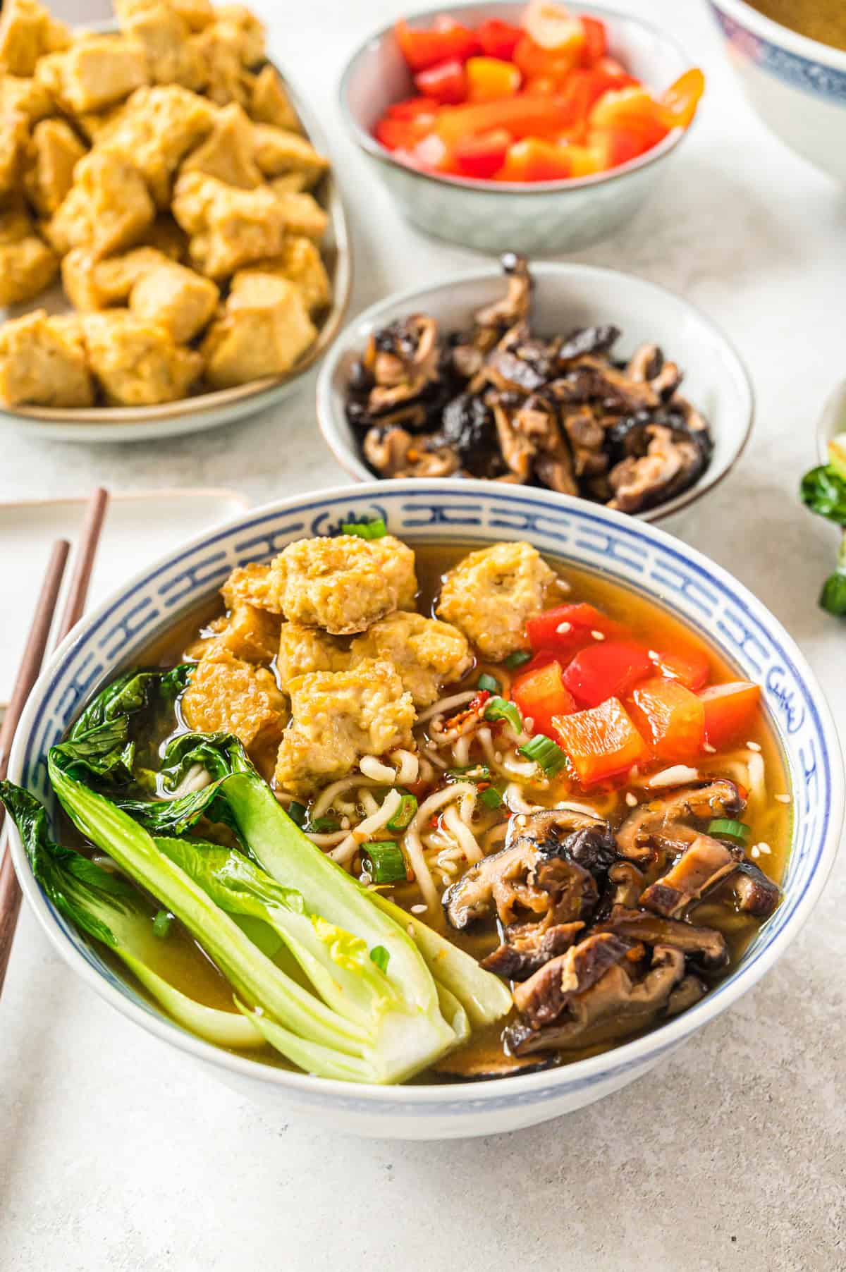 vegane Ramen in blau weißer Schale mit Stäbchen daneben