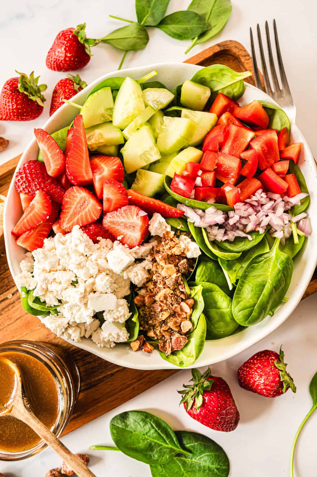 Alle Zutaten für den Spinatsalat nebeneinander in einer weißen Schale von oben