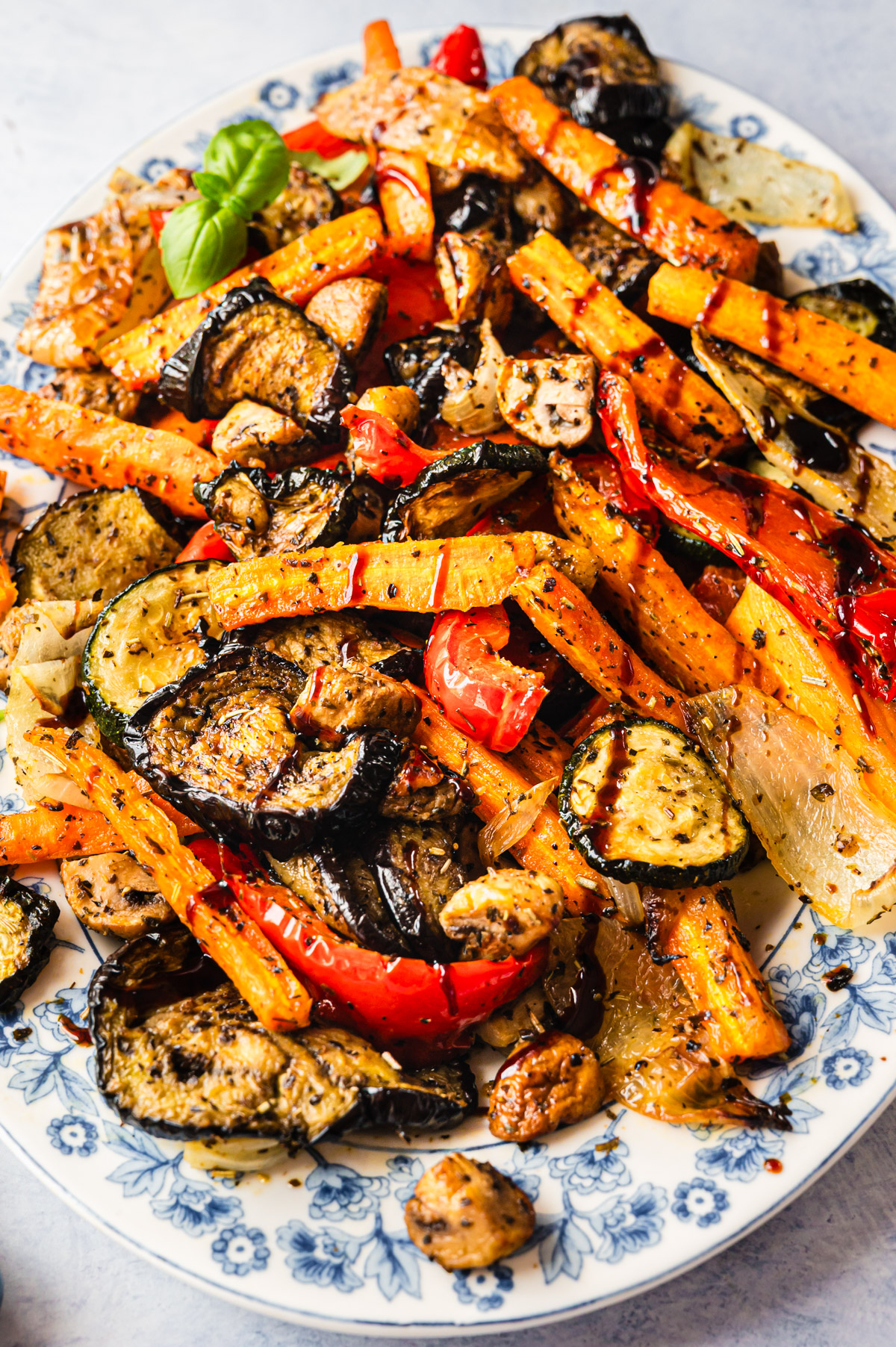 Gemischte Antipasti auf einer weißen Platte mit blauem Blumenmuster am Rand