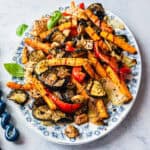 Gemischte Antipasti auf einer weißen Platte mit blauem Blumenmuster am Rand