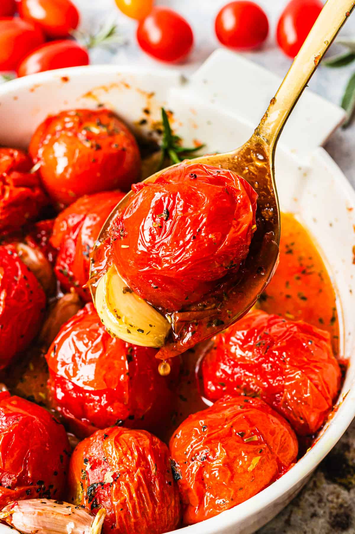 Geschmolzene Tomaten in weißer Form, eine auf goldenem Löffel in Nahaufnahme