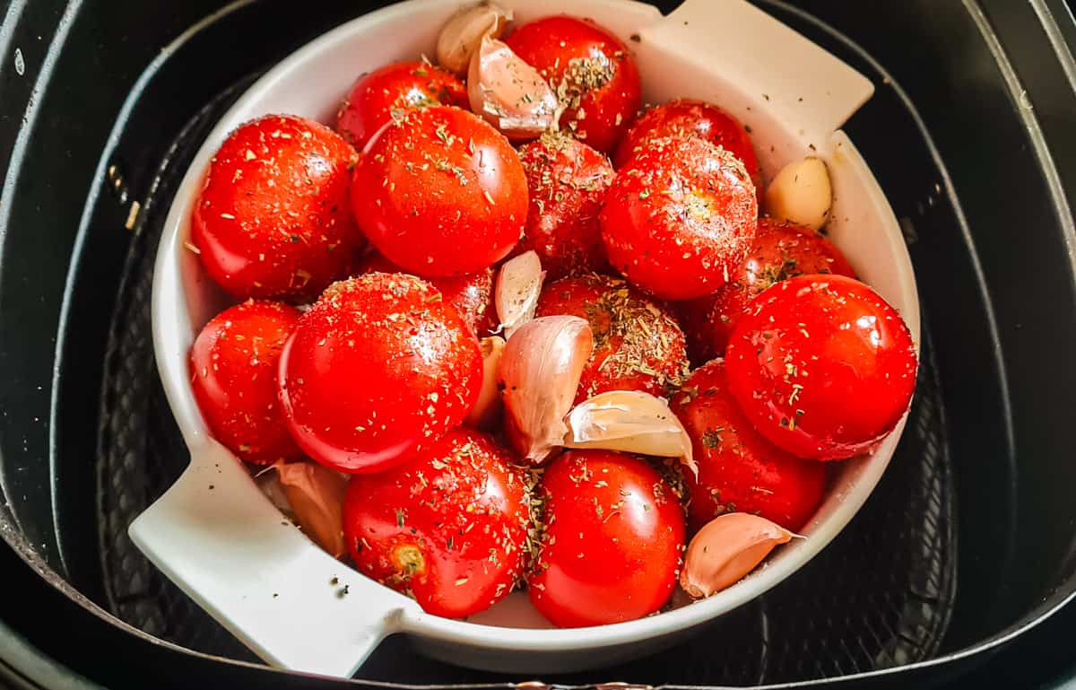 Rohe Tomaten in weißer runder Form im Korb der Heißluftfritteuse