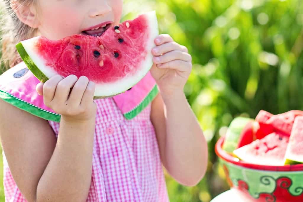 Mädchen isst geschnittene Wassermelone im Sommer
