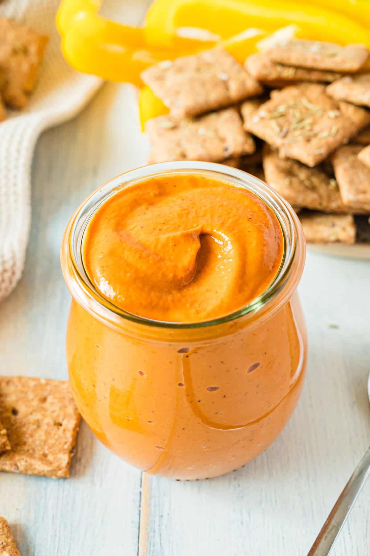 Tomatendip in Glas mit Crackern daneben