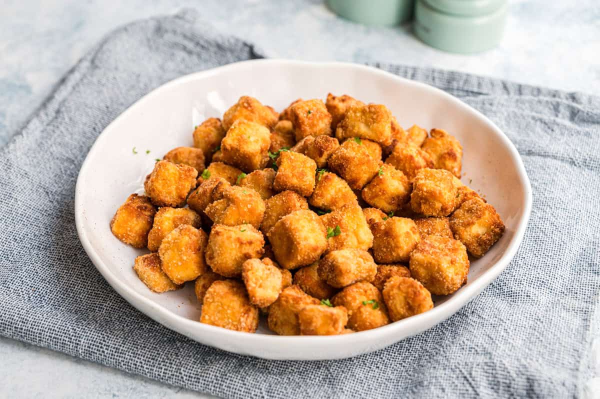 Knuspriger panierter Tofu in weißer Schale mit Petersilie