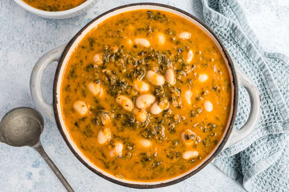 hellgrauer Topf mit Bohnensuppe mit Grünkohl von oben