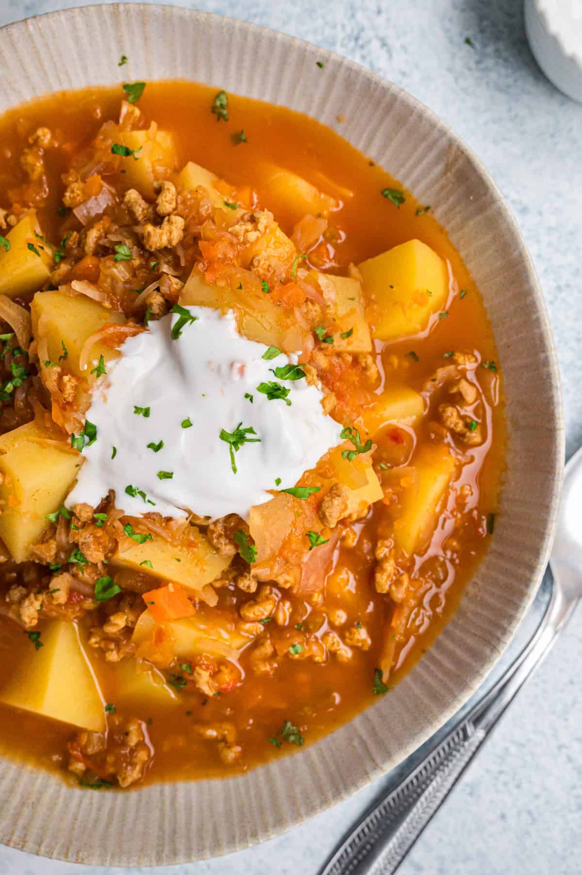 Kartoffelgulasch mit Sauerkraut in hellbeiger Schale von oben