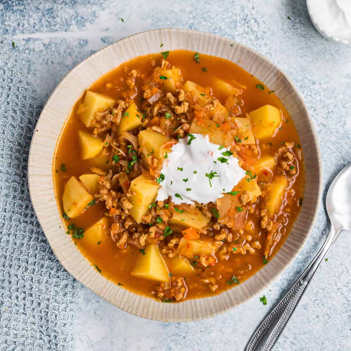 Kartoffelgulasch mit Sauerkraut in heller Schale mit veganem Schmand, von oben