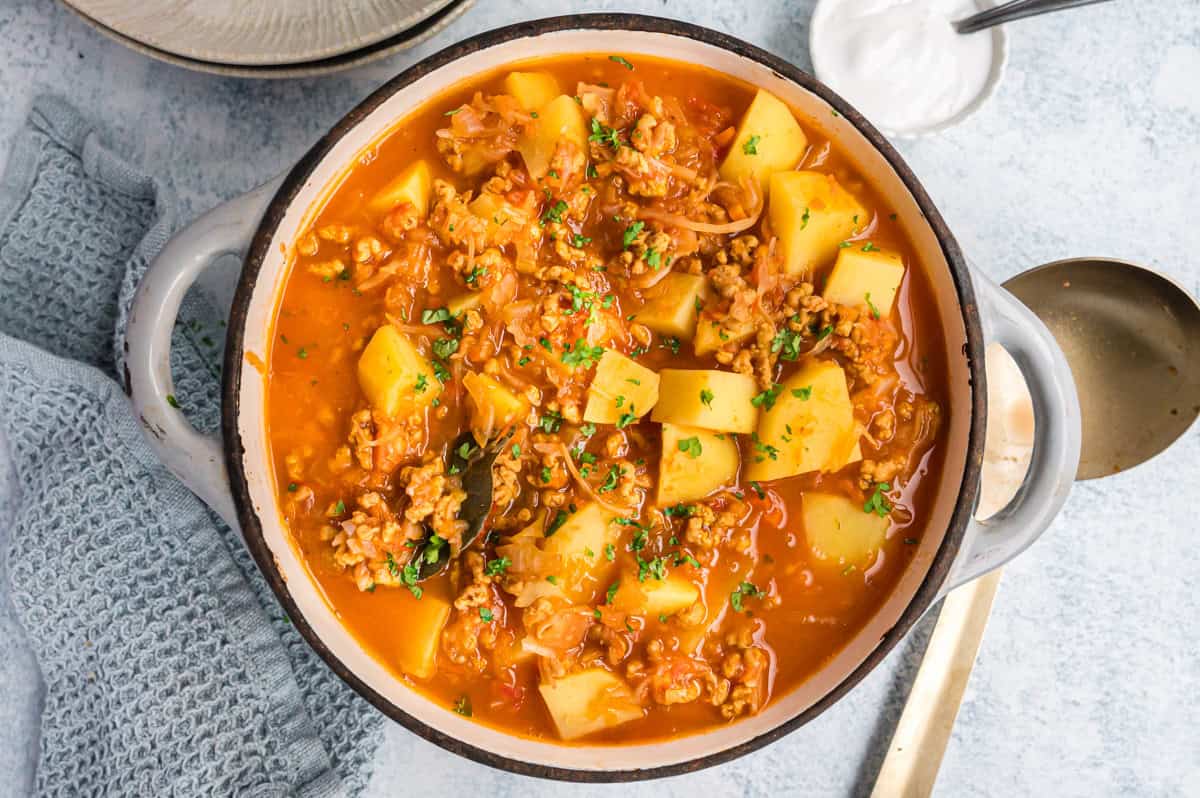 Kartoffelgulasch mit Sauerkraut in hellgrauem Topf von oben