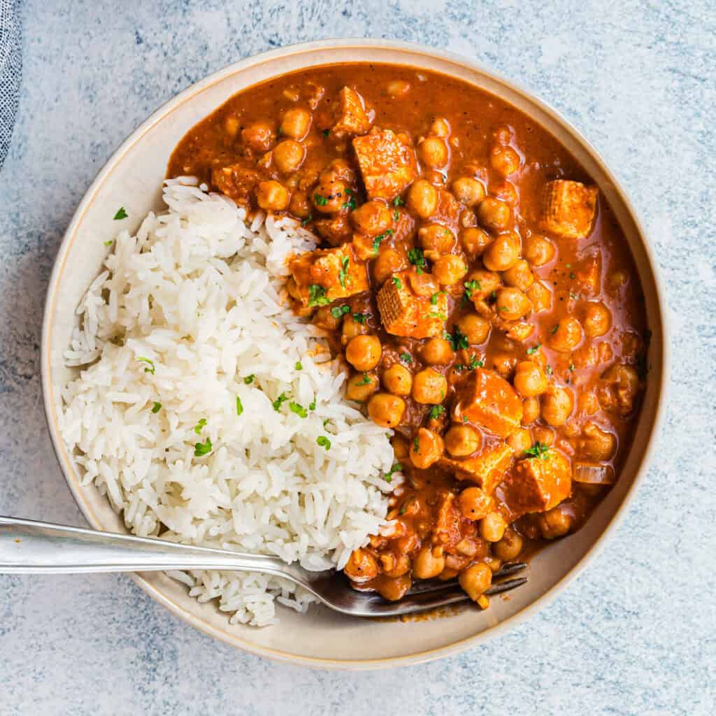 Tikka Masala mit Tofu und Kichererbsen und Reis in heller Schale, von oben