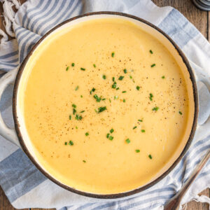 Kartoffelsuppe mit Schnittlauch in hellgrauem Topf von oben