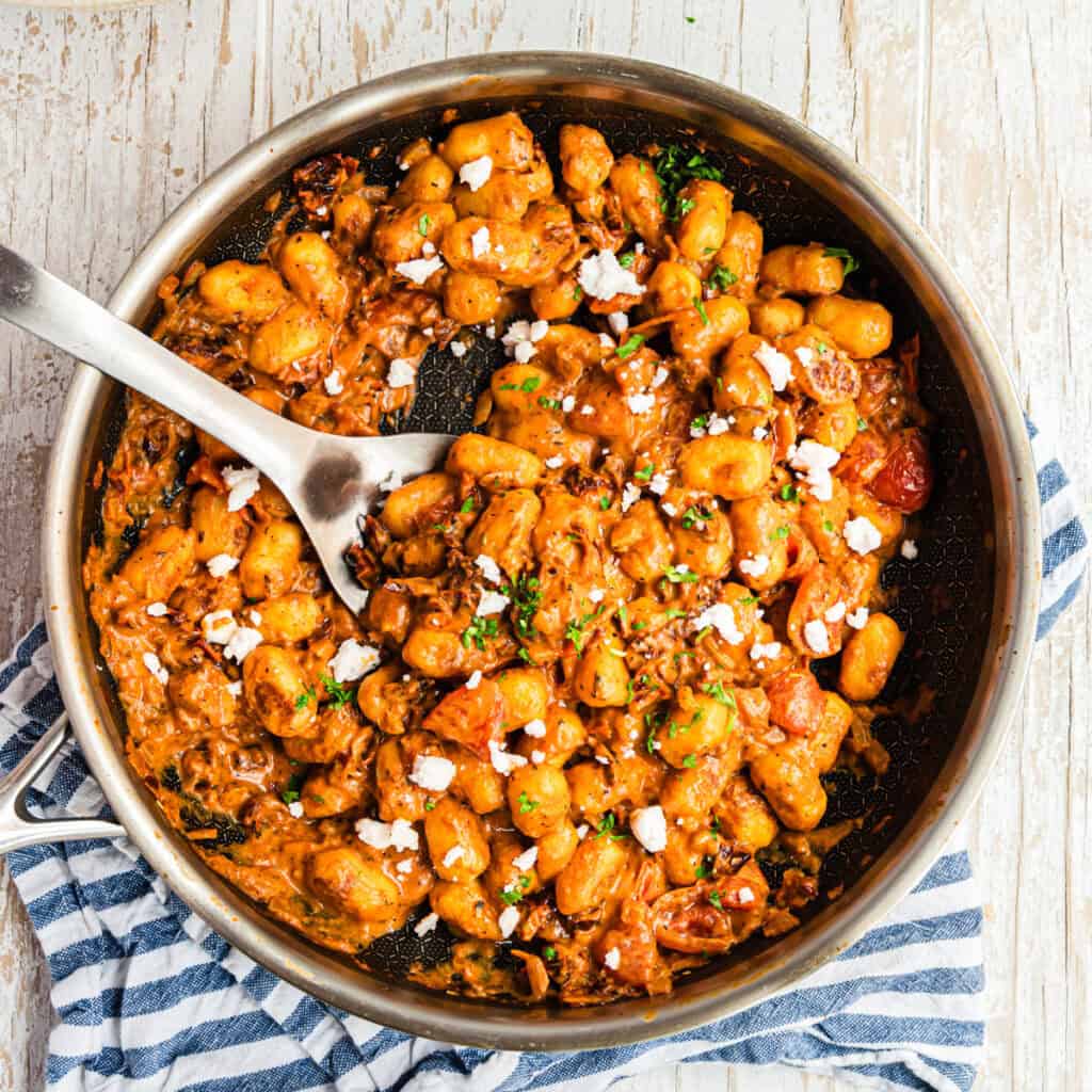 Gnocchi in cremiger Tomatensauce in Pfanne mit Feta und Petersilie, von oben