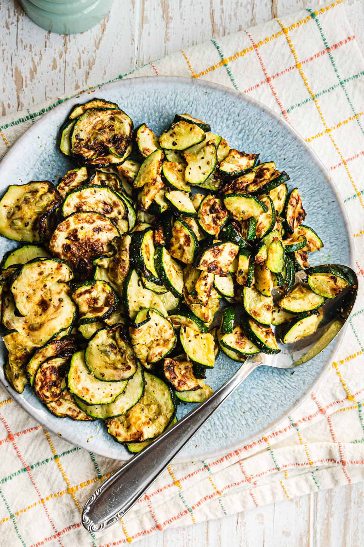 Gebackene Zuchini auf blauem Teller von oben