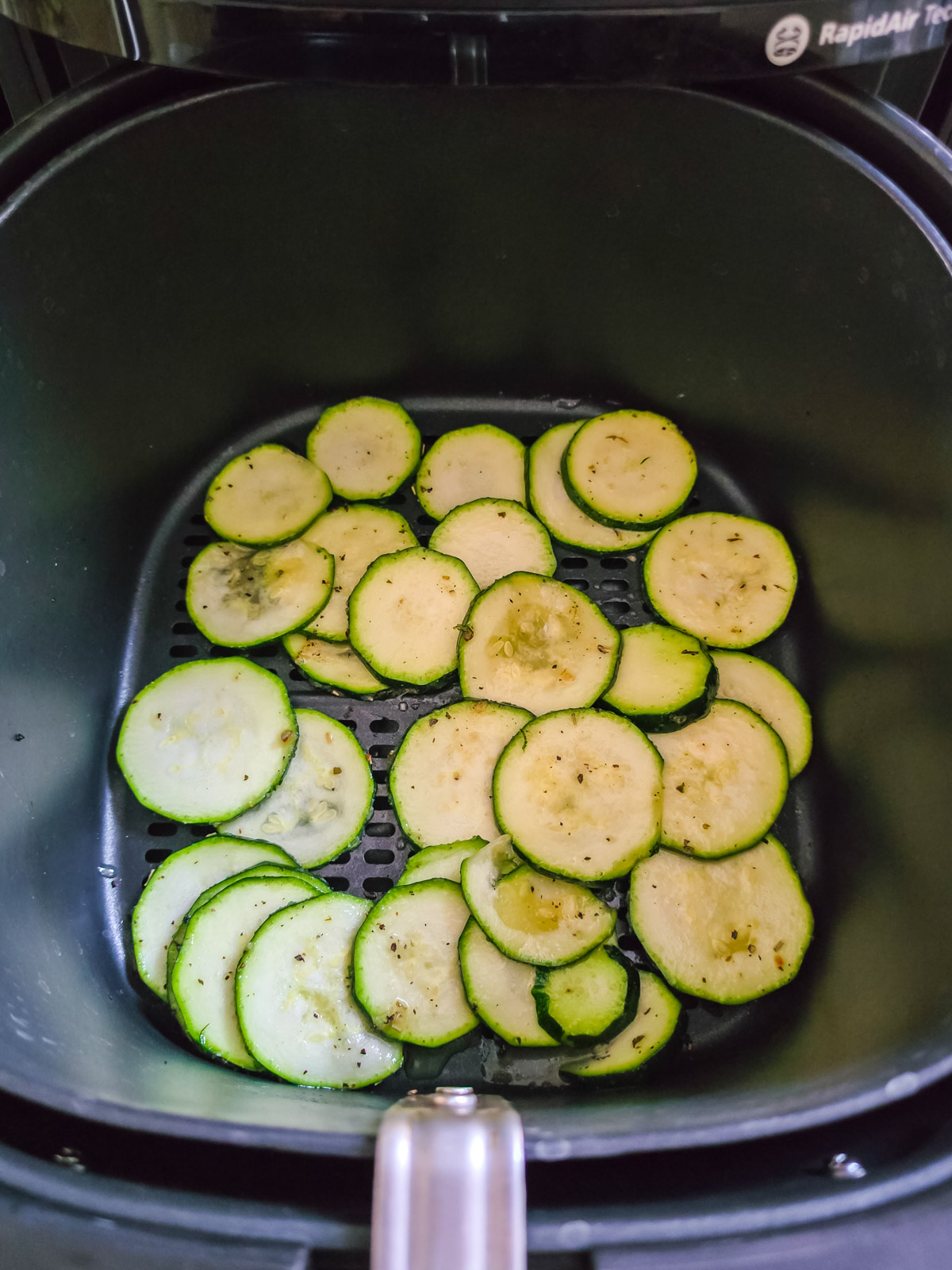 Rohe Zucchinischeiben im Korb des Airfryers