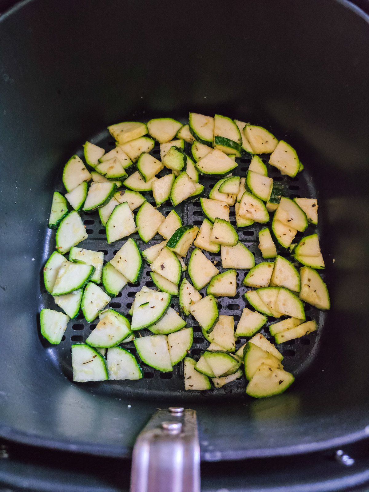 Rohe Zucchinistücke im Korb des Airfryers