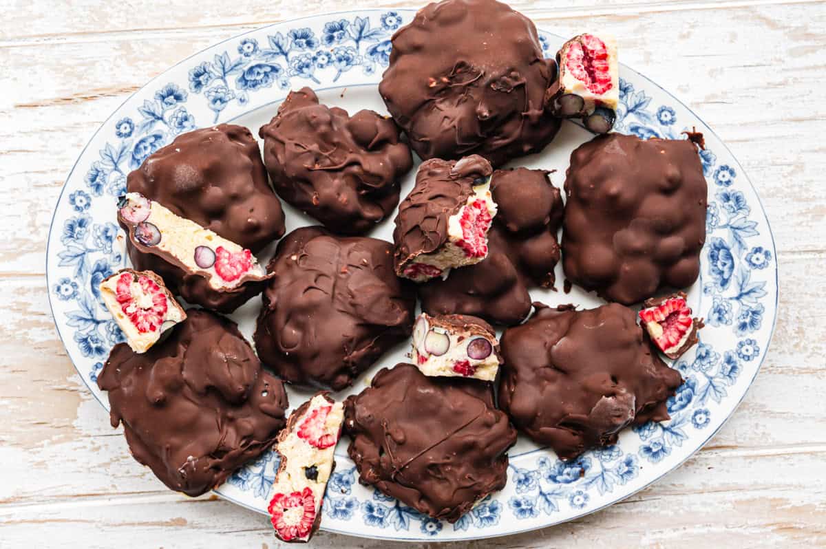 Frozen Yoghurt Bites, einige aufgeschnitten, auf Servierplatte mit blauem Blumenmuster, von oben