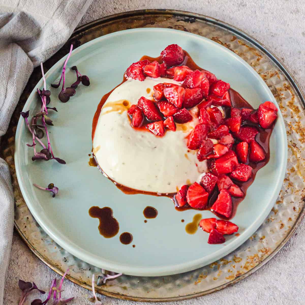 Panna Cotta mit Ziegenkäse und Erdbeeren auf hellblauem Teller
