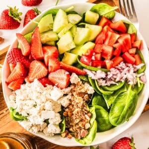 Alle Zutaten für den Spinatsalat nebeneinander in einer weißen Schale von oben