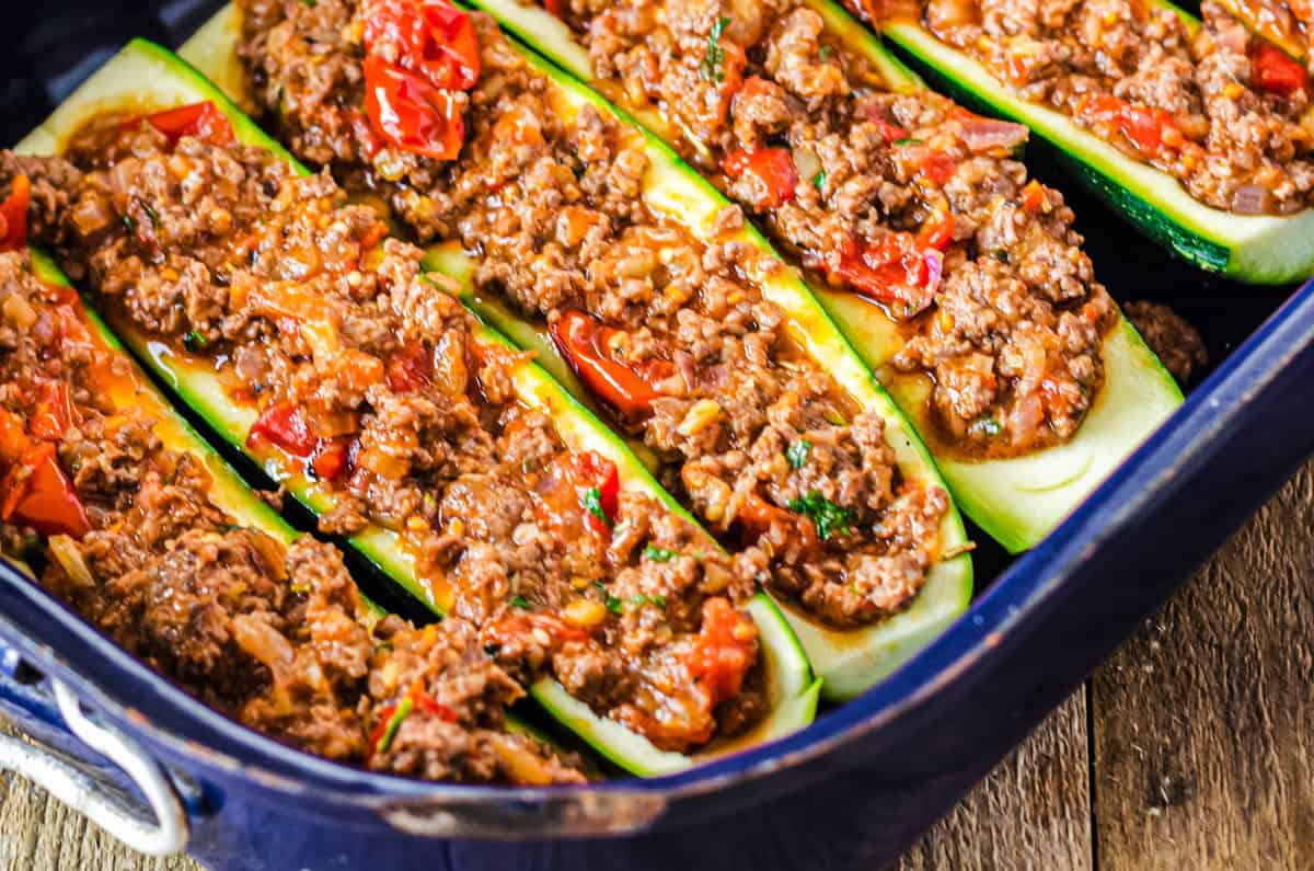 gefüllte Zucchini in blauer Ofenform vor dem Backen
